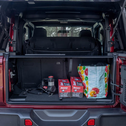 Straight-on view of EZTrunk with items inside in cargo area of Jeep Wrangler with trunk door open, showing storage setup.