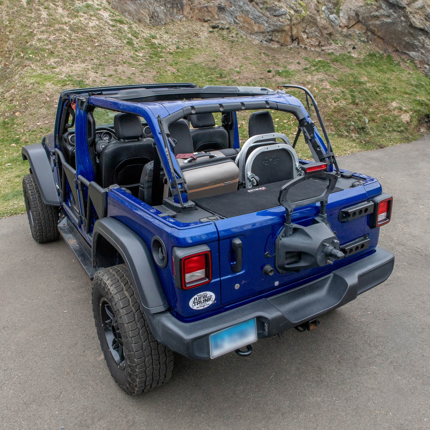 Blue Jeep with trunk closed, showing top of EZTrunk inside cargo area for low-profile, secure storage solution.