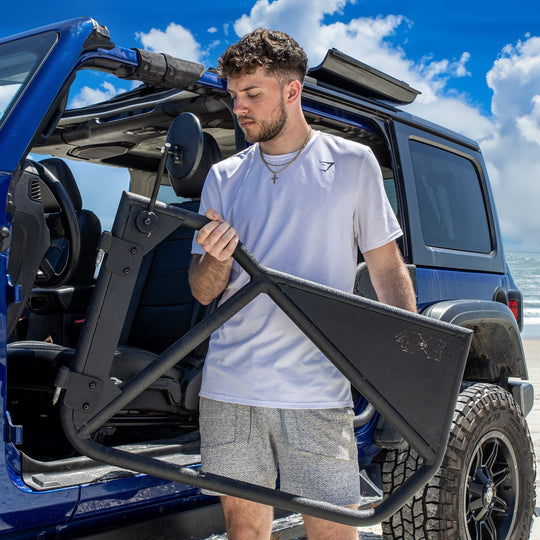 Man installing Phantom aluminum doors on Jeep, showcasing removable design and rugged, off-road-ready aftermarket style.