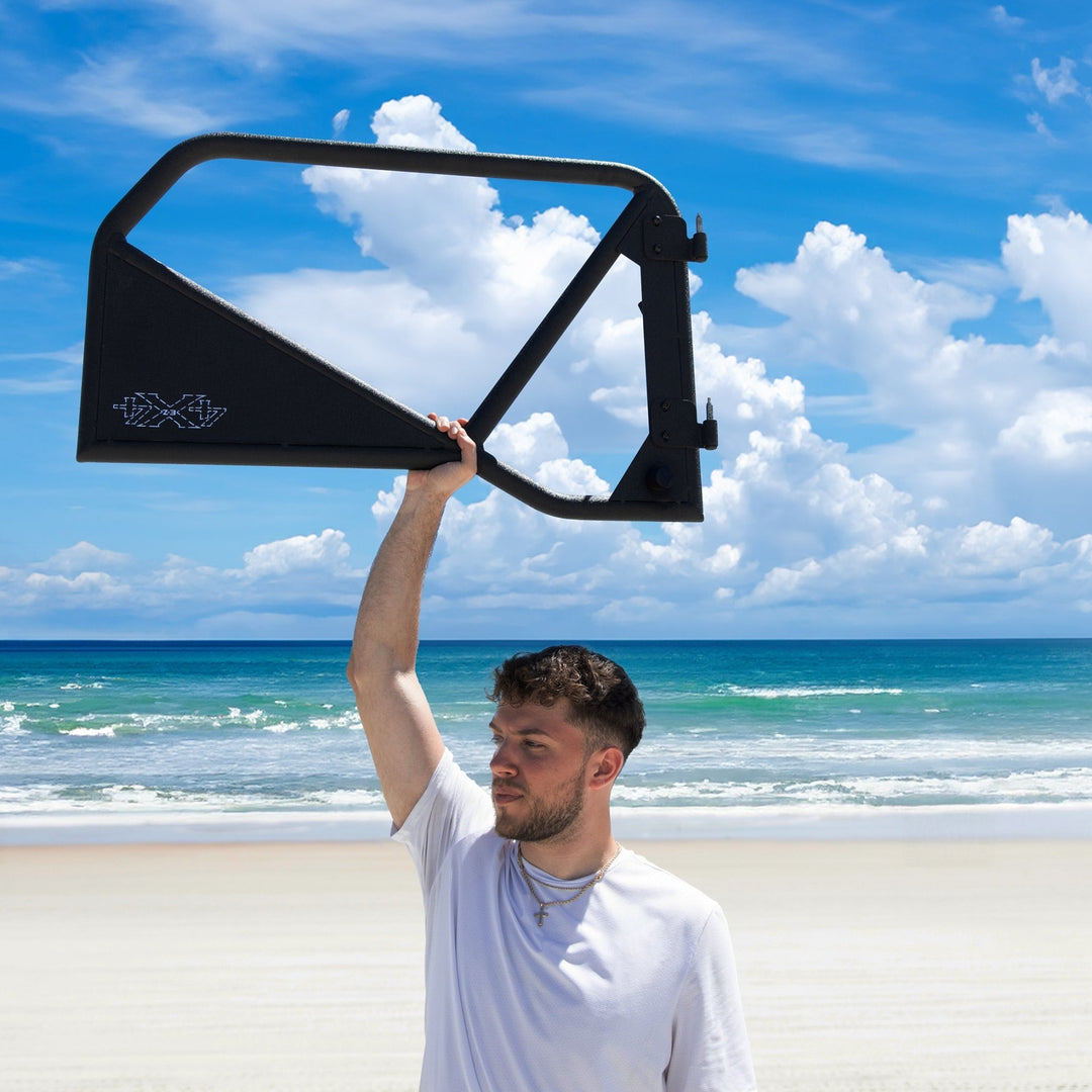 Man lifting black Phantom aluminum door overhead, showcasing lightweight, removable design and rugged durability.