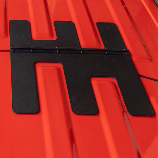 Close-up of EZ Flip-Top hinge on red Jeep roof, showing durable hardware for secure, easy Freedom Panel operation.