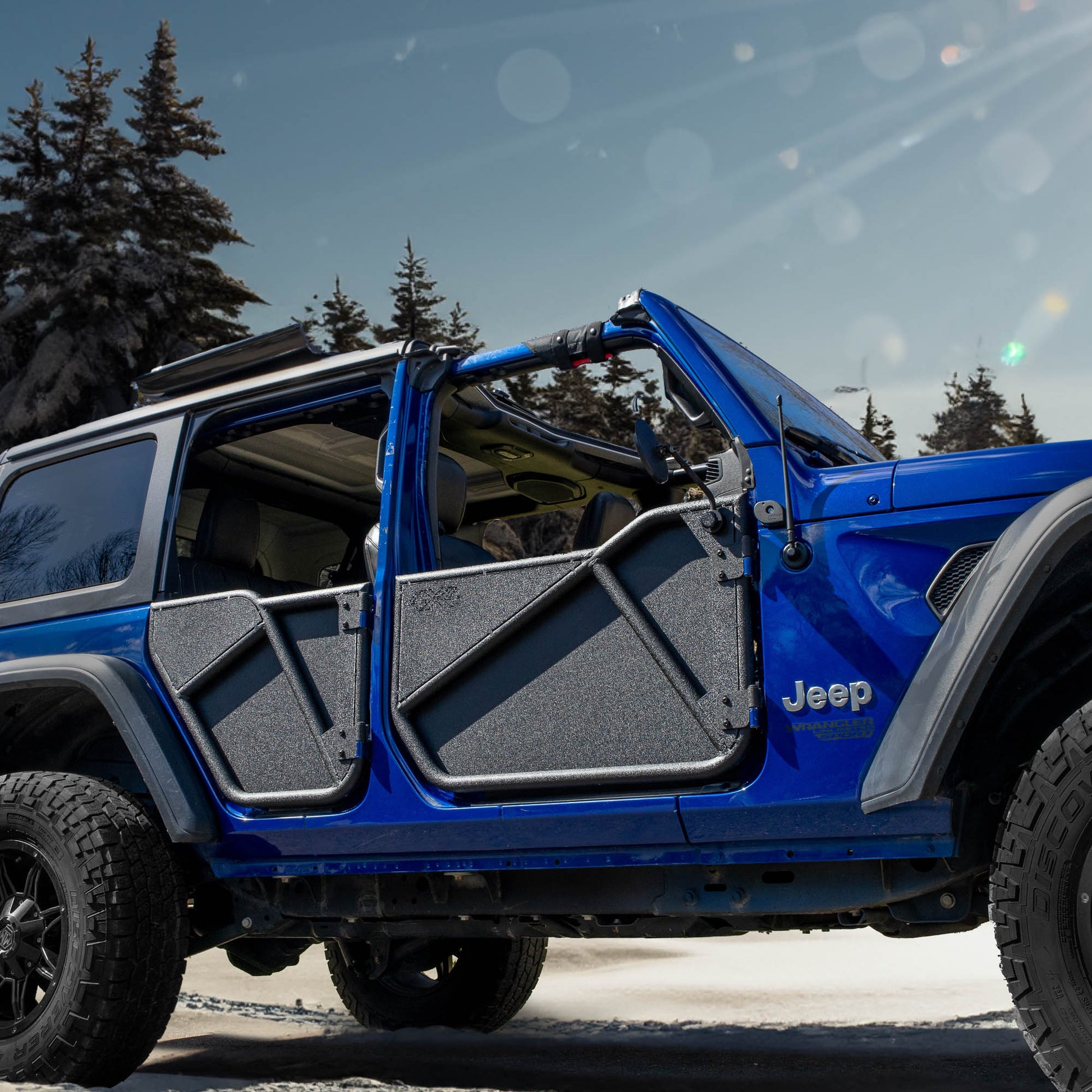 Blue Jeep with black Phantom aluminum doors and all-weather panels installed, showcasing its removable trail-ready design.