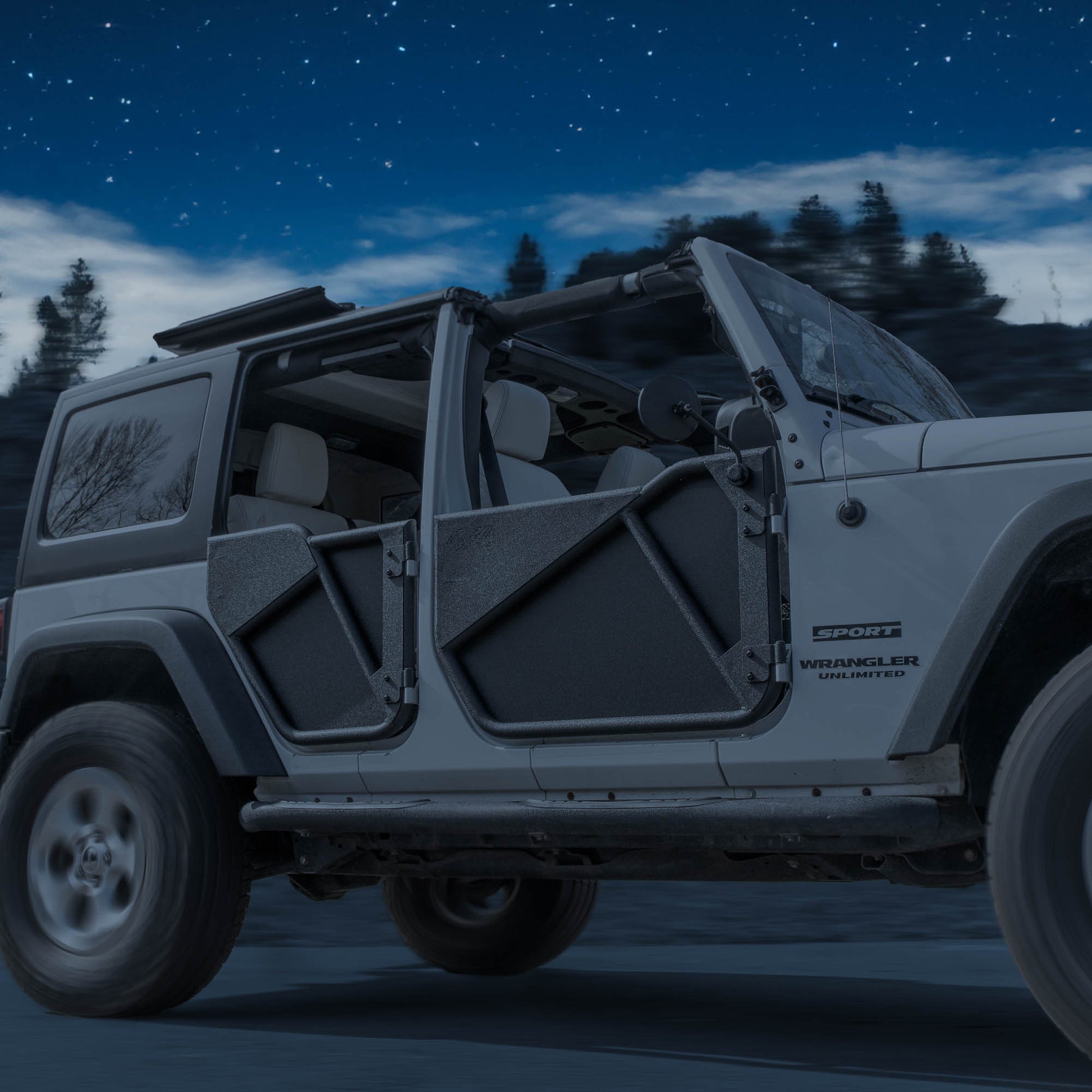 Grey Jeep with black removable Phantom aluminum doors and all-weather panels, shown at night for rugged, off-road style.