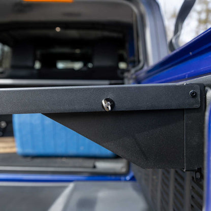 Close-up of the EZ4X4 Single Level Tailgate Table corner on a Jeep, showing the sturdy mounting bracket and latch mechanism for secure, space-saving storage.