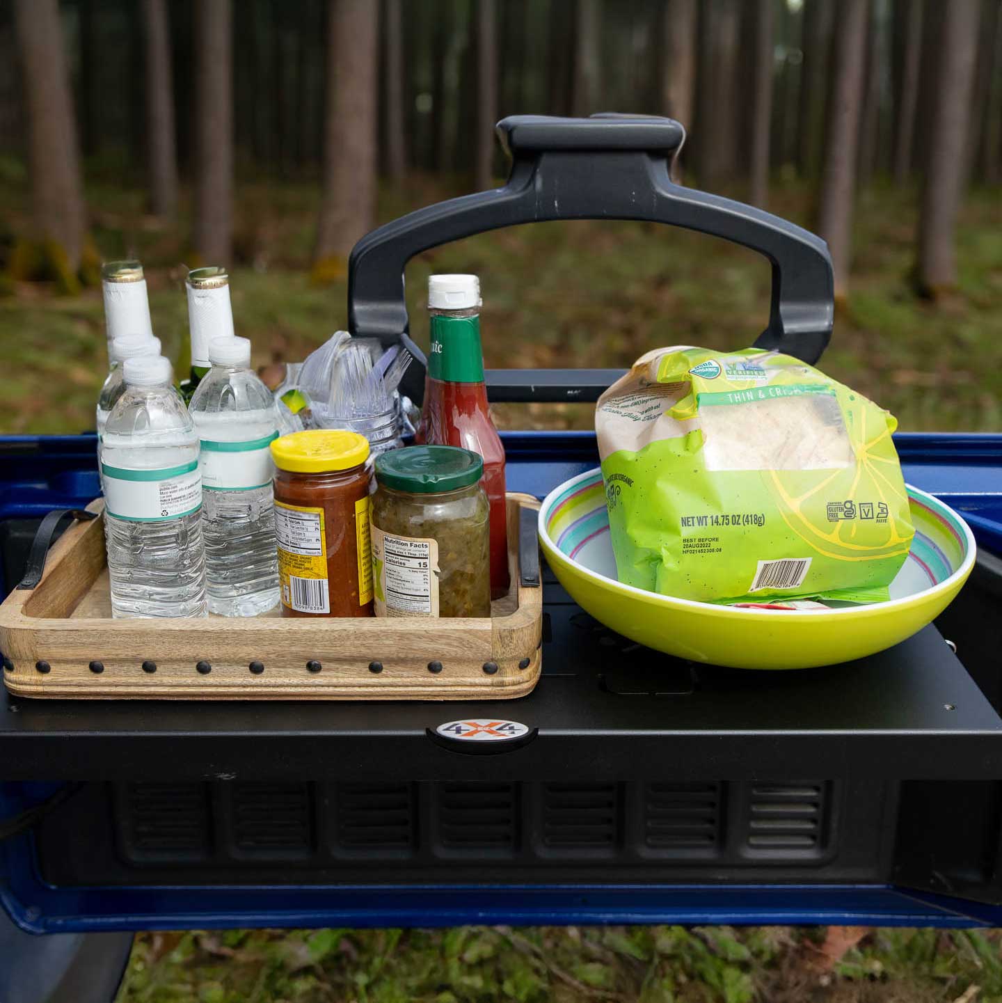 Close-up view of EZ4X4 Single Level Tailgate Table mounted on a Jeep, fully deployed and holding food and drinks.