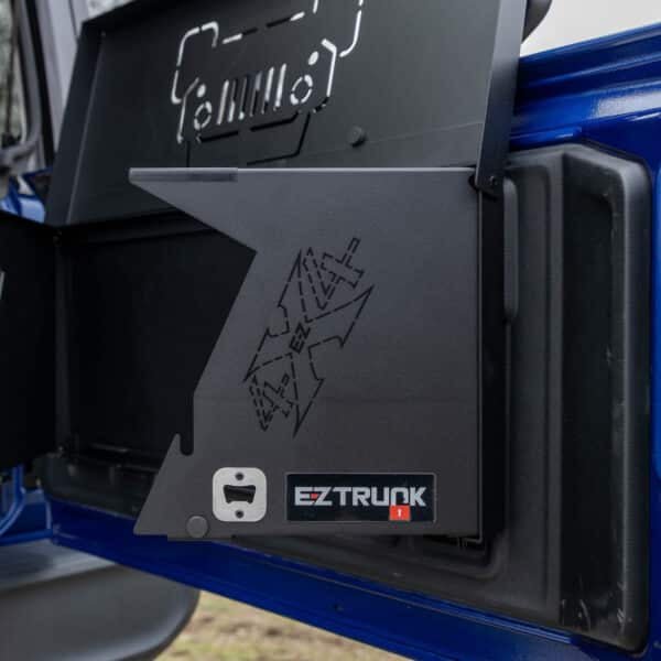 Close-up of built-in bottle opener with EZ4X4 logo on Jeep tailgate table, showcasing functional design and durability.
