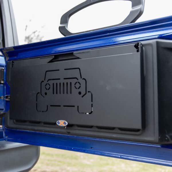 Tailgate table installed on Jeep shown folded up, highlighting space-saving design ideal for off-roading and camping.