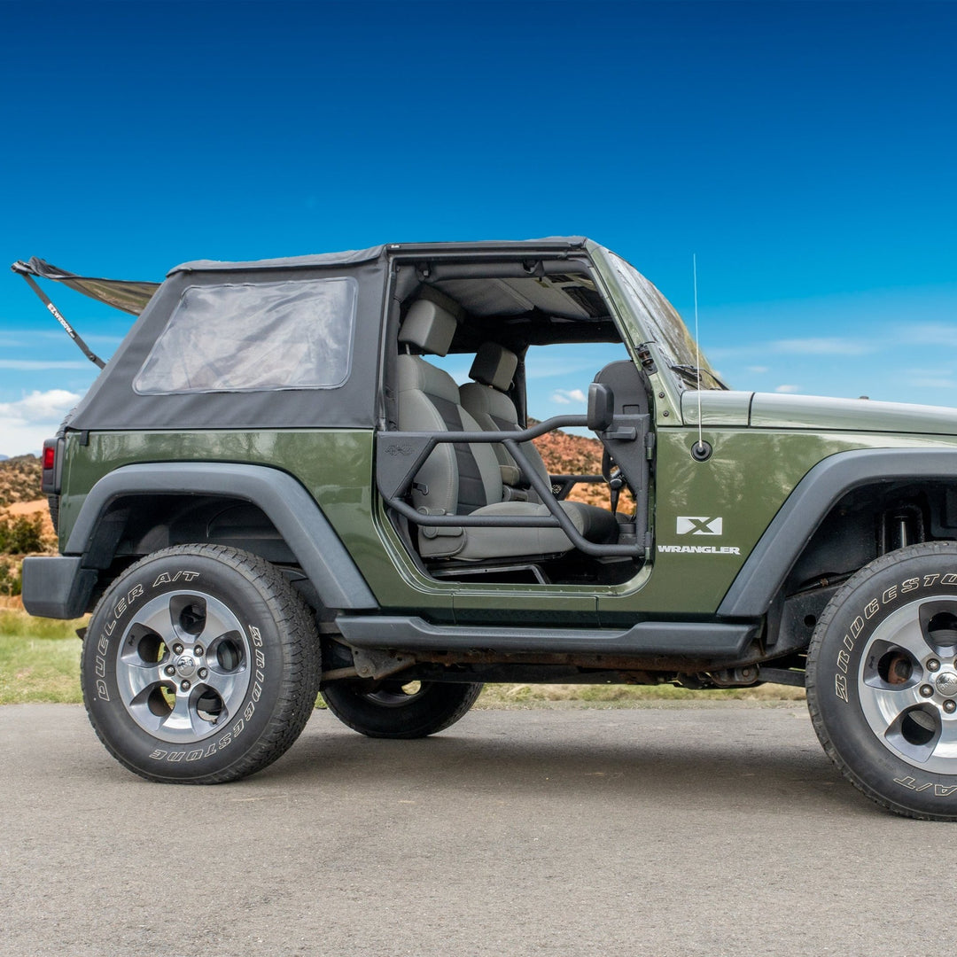Green Jeep with EZ4X4 Razor half-tube doors and EZWindow driving on road, showcasing rugged, off-road-ready design.