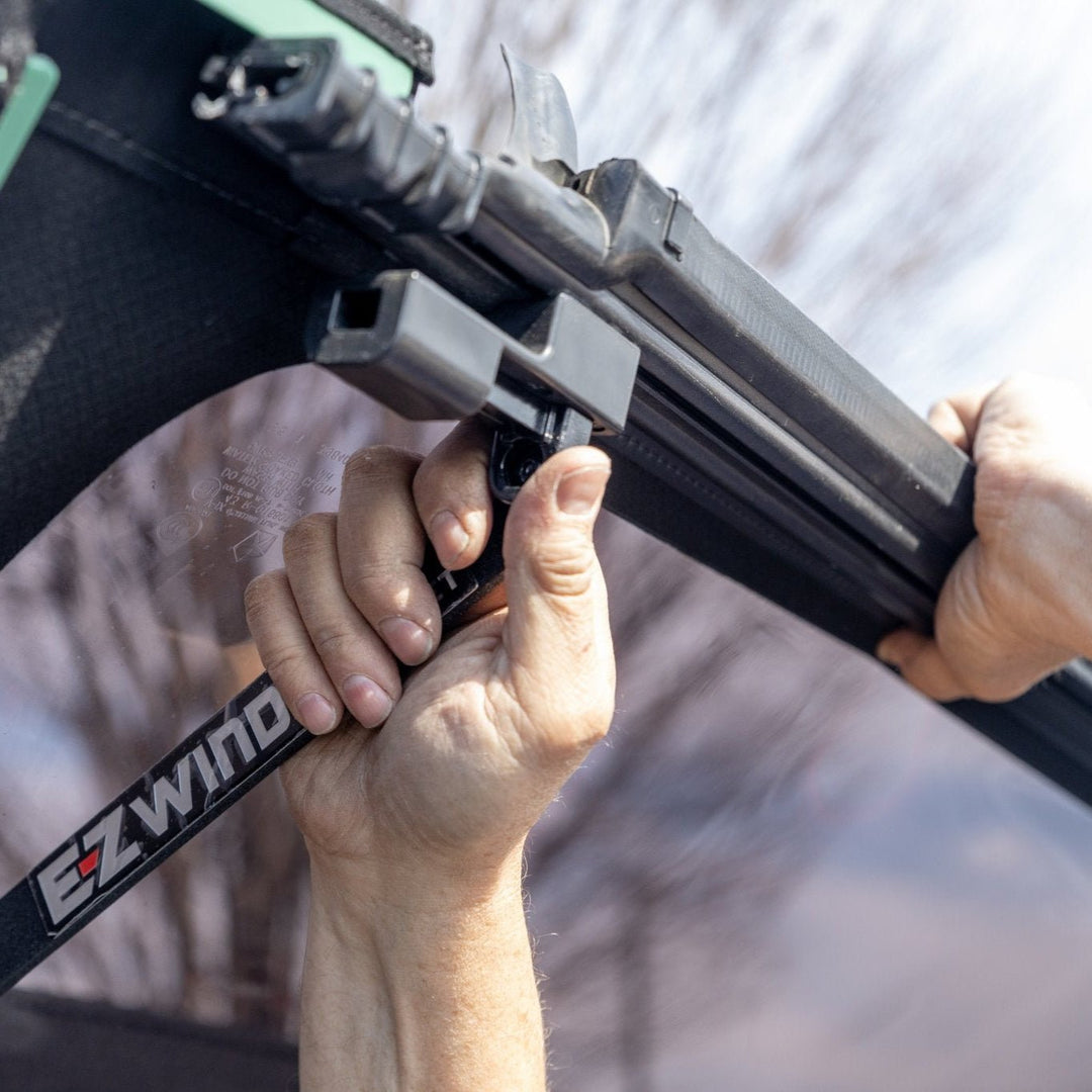 Close-up of hand setting up EZWindow locking mechanism, showing secure, easy-to-use hardware for Jeep cargo ventilation.