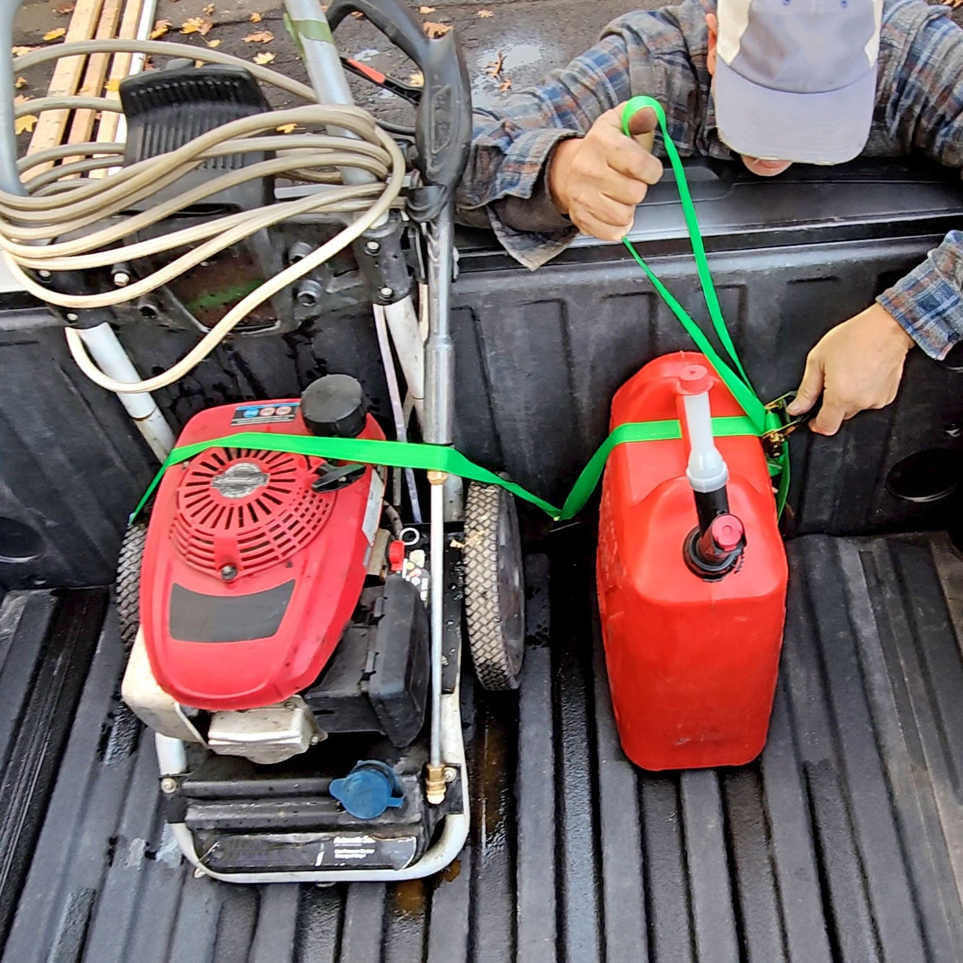Man securing red canister in truck bed with Truck Buddiez straps, showing heavy-duty, adjustable cargo safety solution.