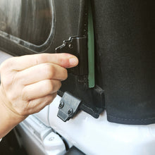 Person installing an aftermarket soft top clip on a Jeep Wrangler, showing secure attachment of the soft top.