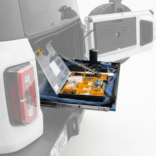 EZ4X4 Extreme EZTRUNK shelf extended from a white Ford Bronco, being used as a portable work table to hold tools.