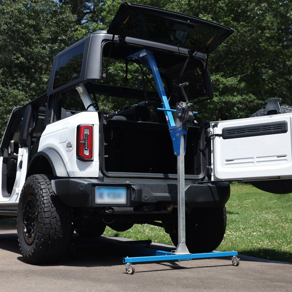 Hardtop of white Bronco being removed with hardtop lift, showing easy, one-person operation for safe roof removal.